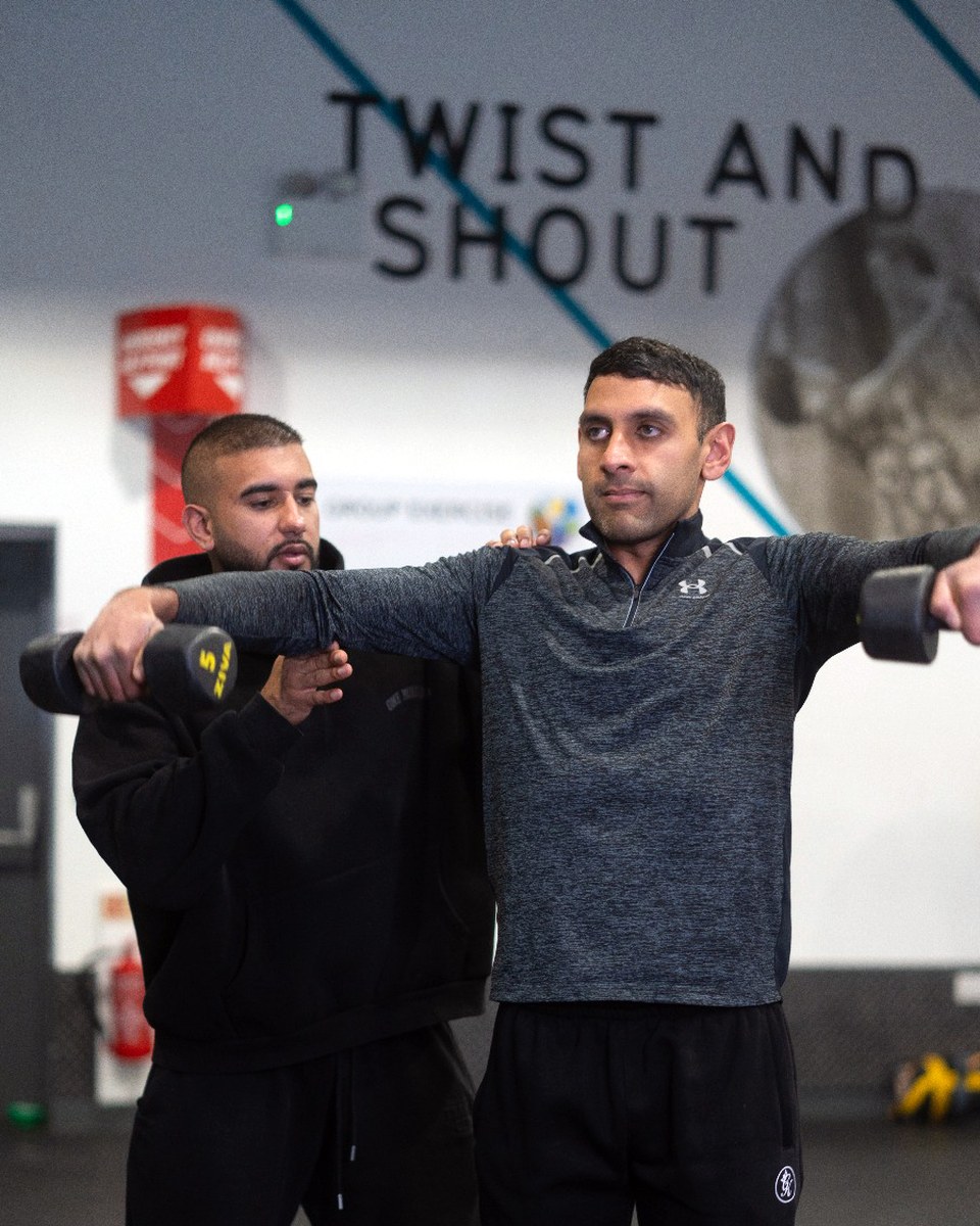 Personal trainer coaching correct lifting technique